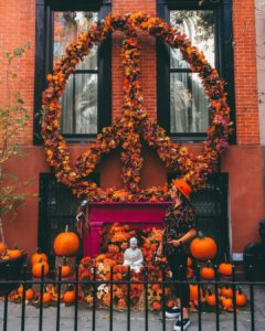 Woman standing in front of building in Chelsea NYC with Halloween decorations
