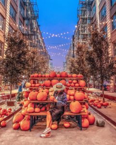 Woman sitting in front of Halloween decor in Industry City NYC