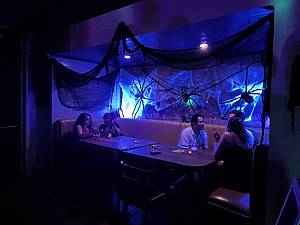 People sitting at tables in a bar at a Halloween pop-up in NYC