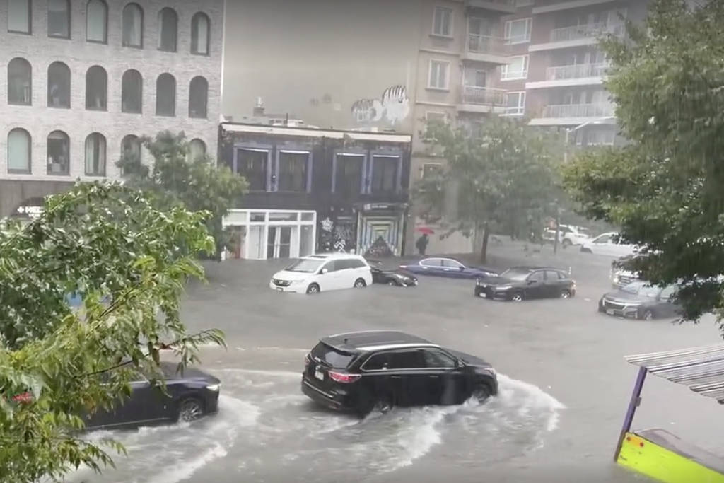 Cars driving through a flooded street in NYC