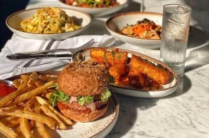 Various plates of food such as a burger and fries at Queen's Room in Astoria, Queens