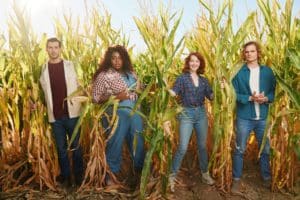 Cast of Shucked musical in a corn field