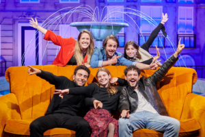 People posing on a couch at The FRIENDS™ Experience